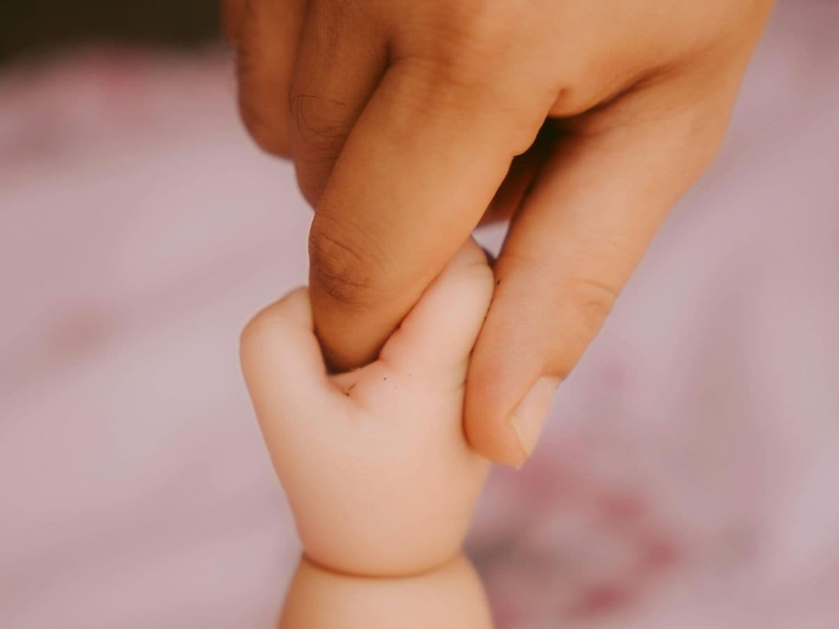 A parent's hand held by a small child's hand